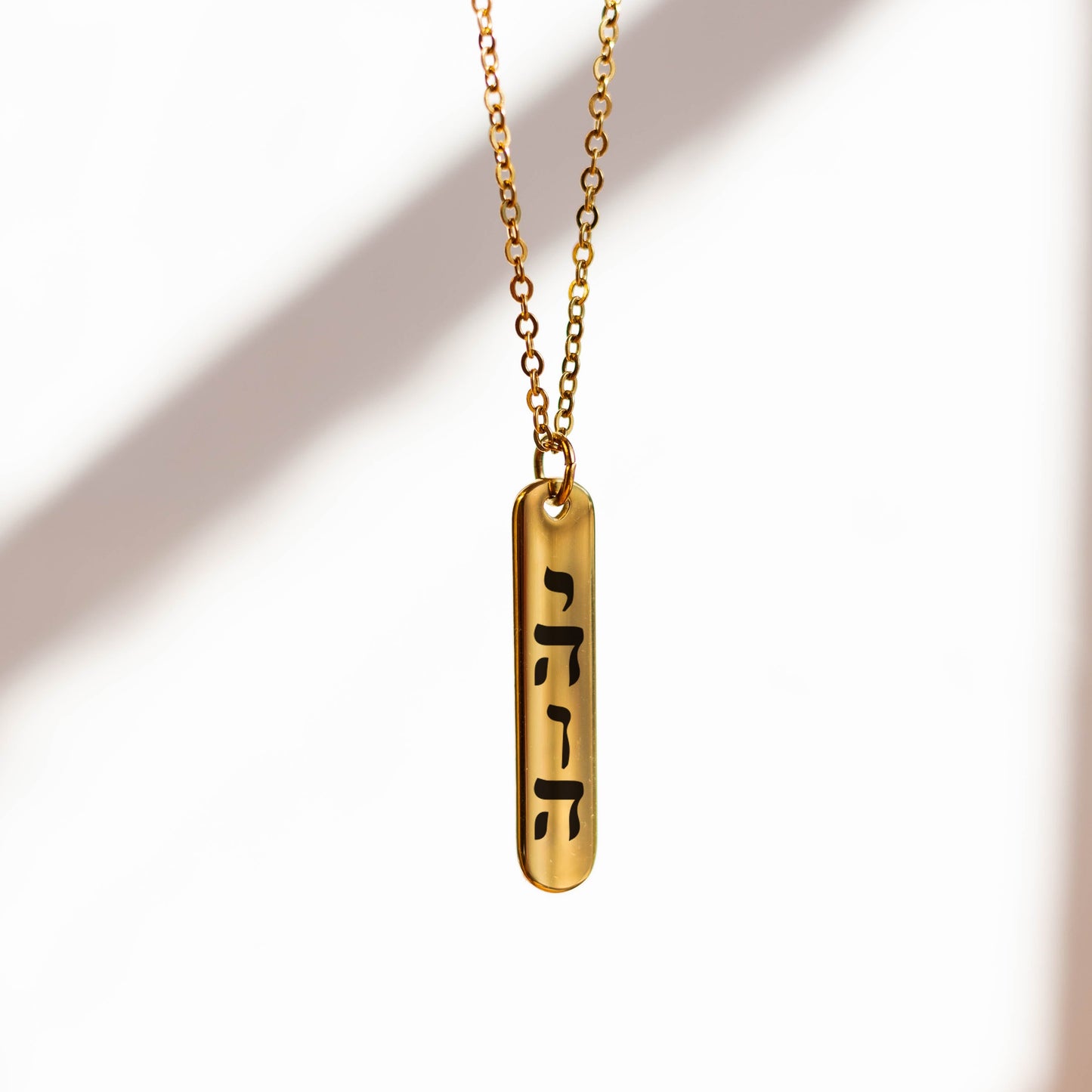 YHWH Gold necklace with a pendant on a white background