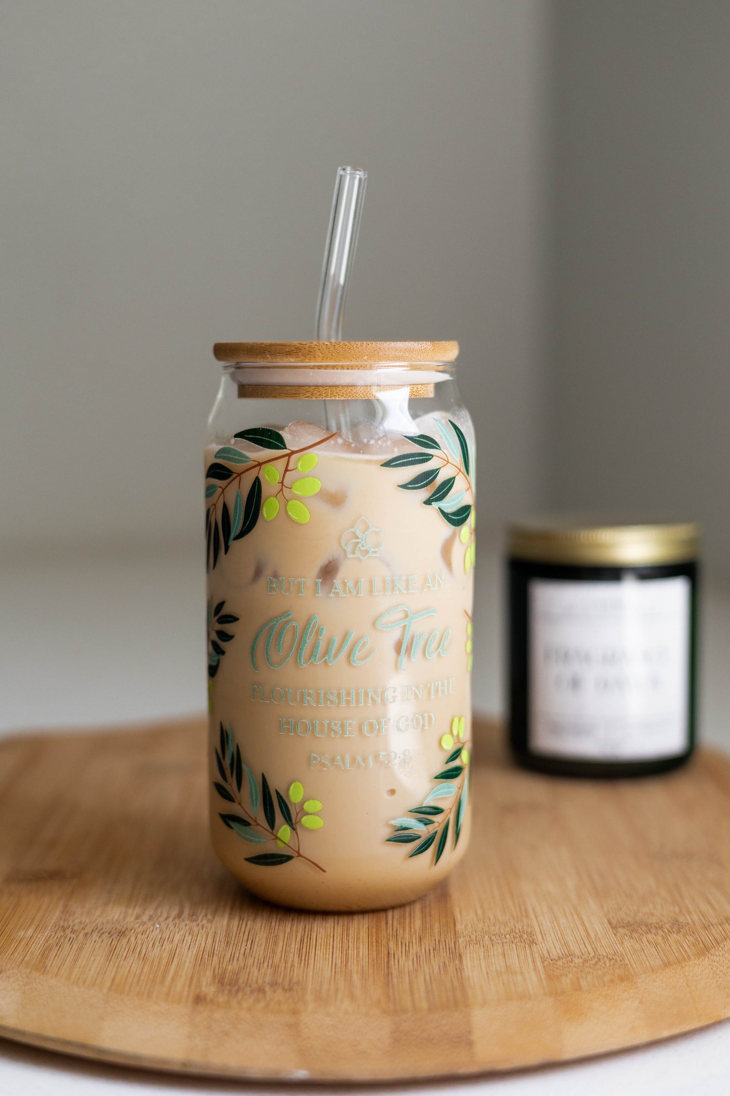Glass jar with floral design and wooden lid on a wooden surface