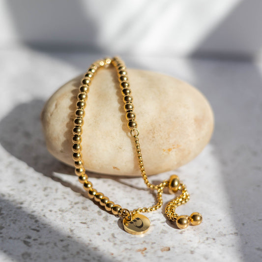 Gold bracelet on a stone with soft shadows